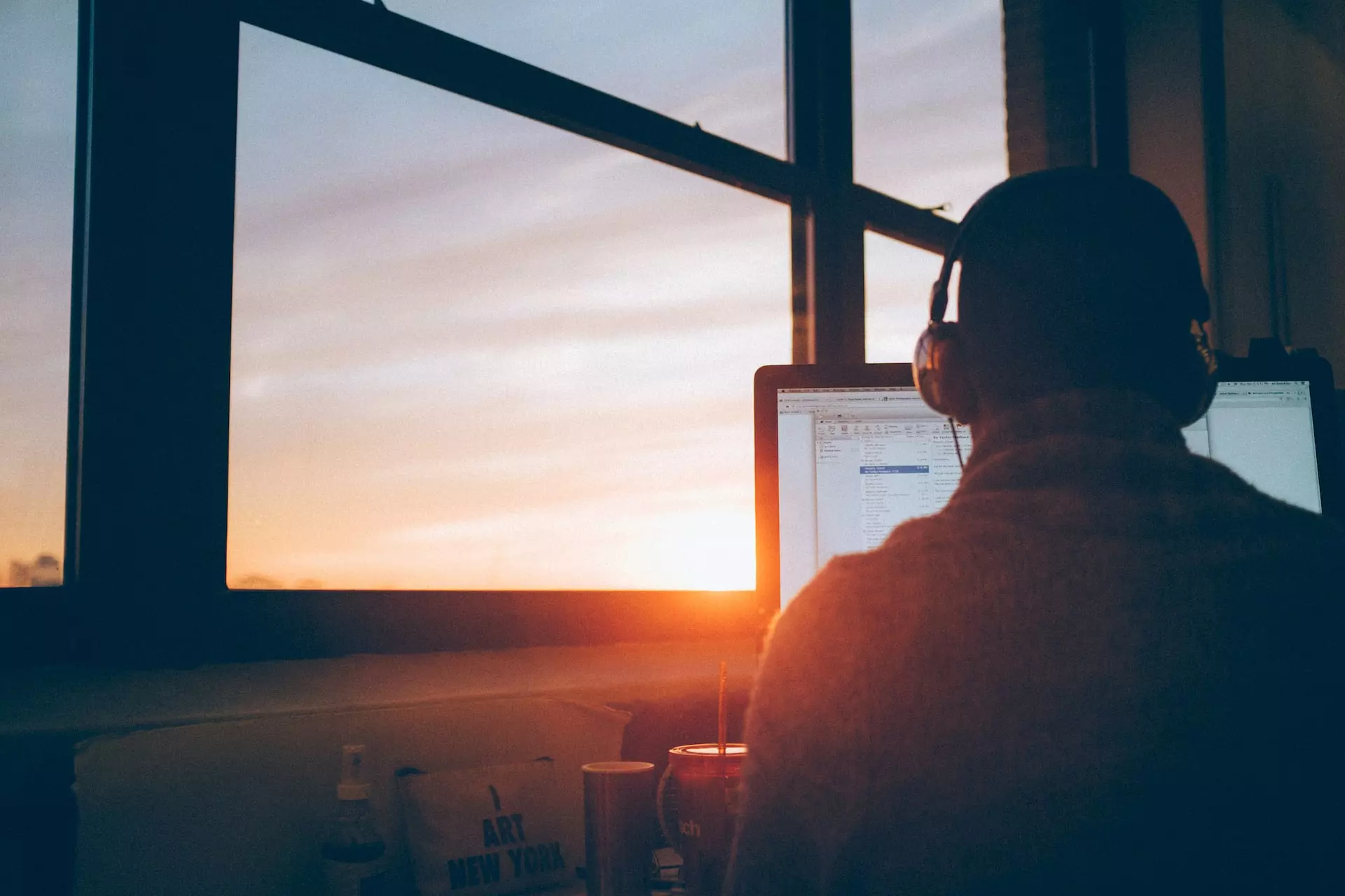 A person wearing headphones looking at a computer screen