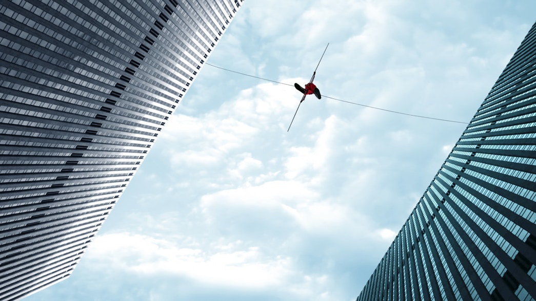 A tightrope walker between two skyscrapers