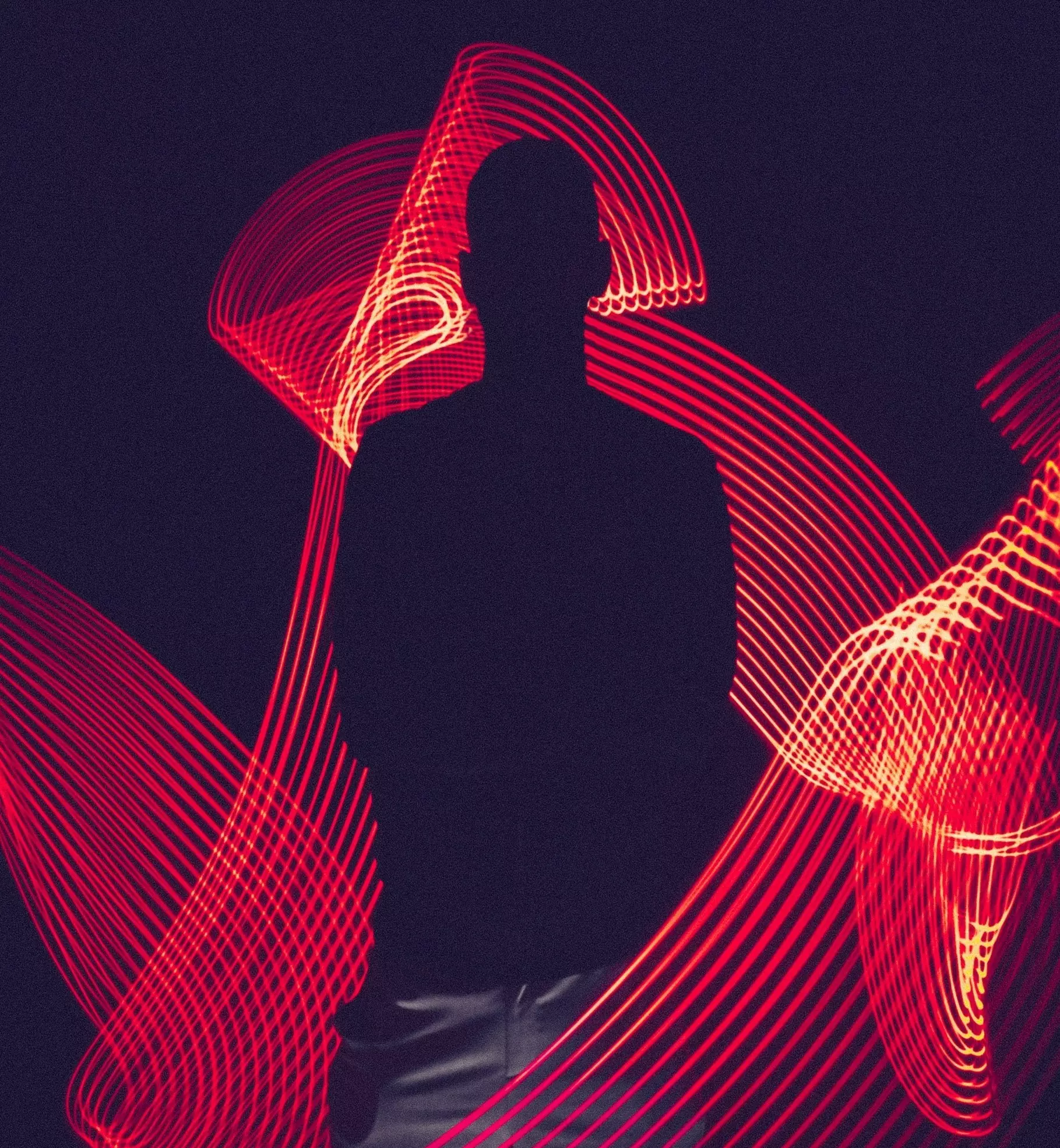 Silhouette of a man against glowing light trails