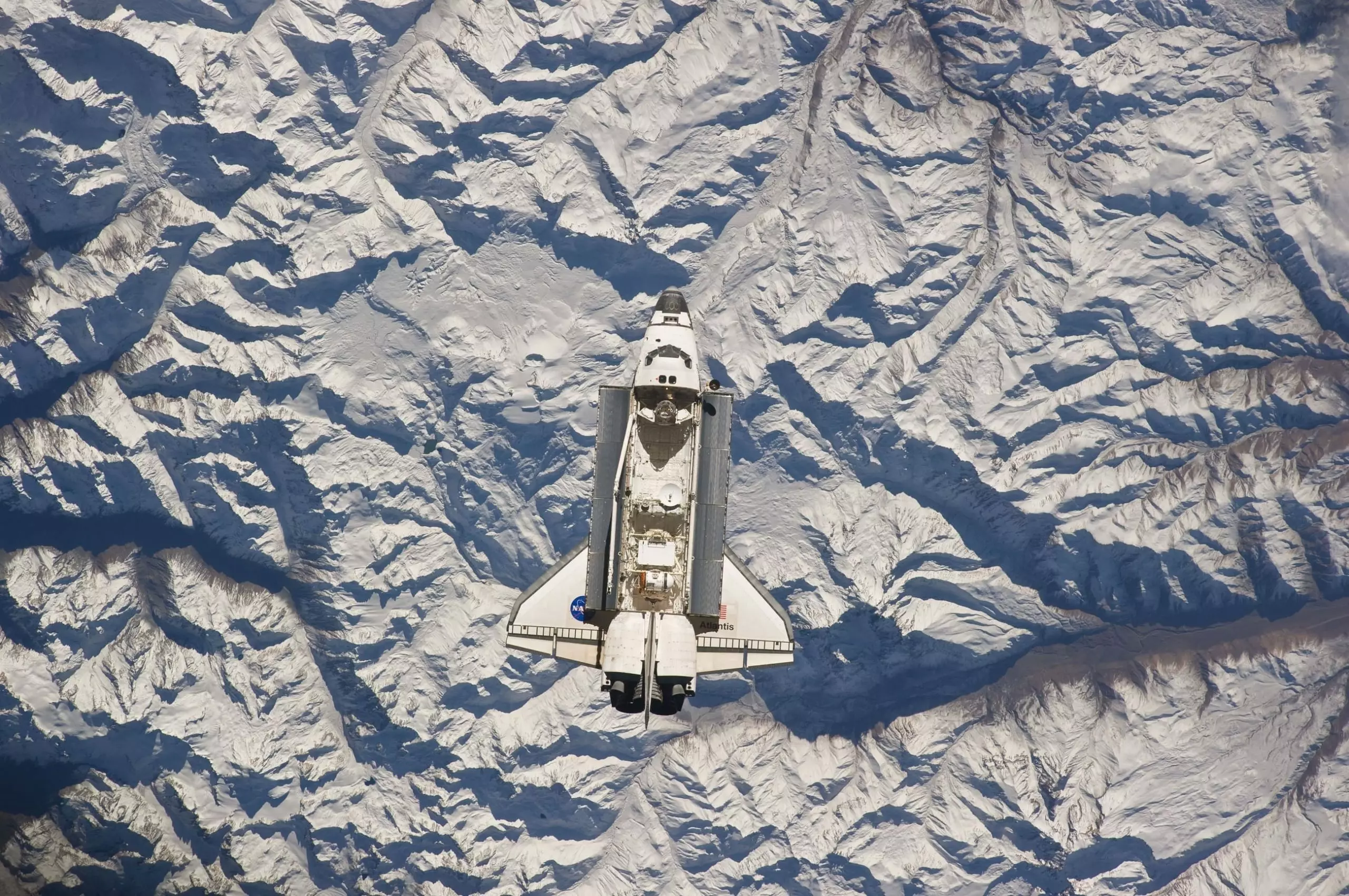 Aerial view of space shuttle above mountain tops