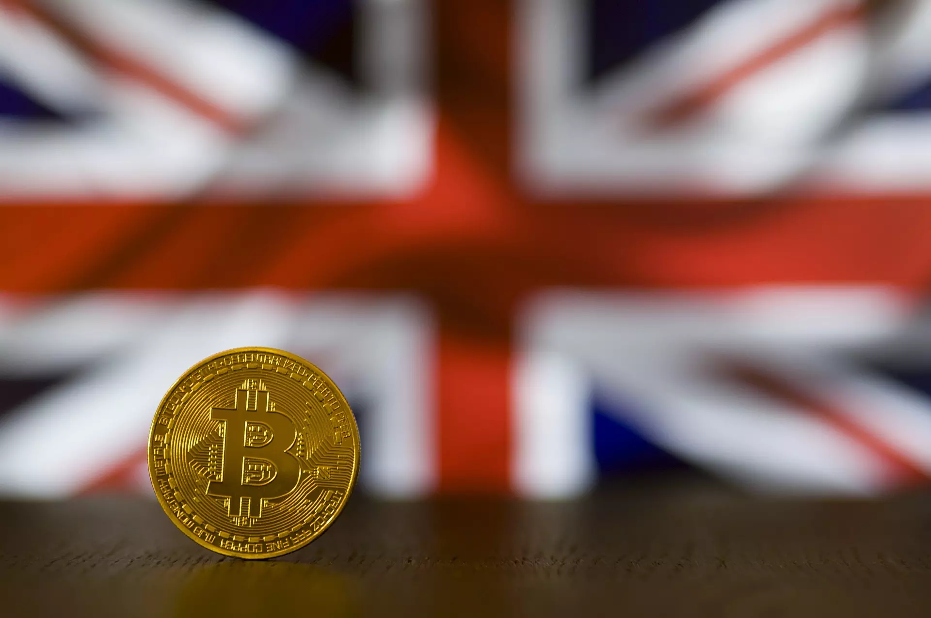 A cryptocurrency coin in front of a Union Jack
