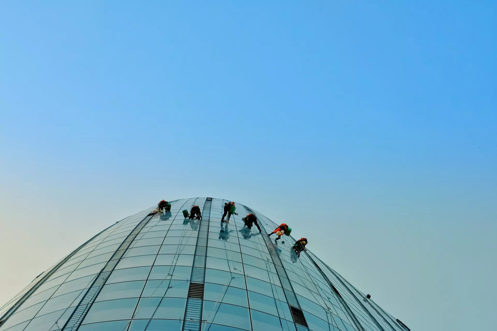 Skyscraper viewed from below with window cleaners visible on the side