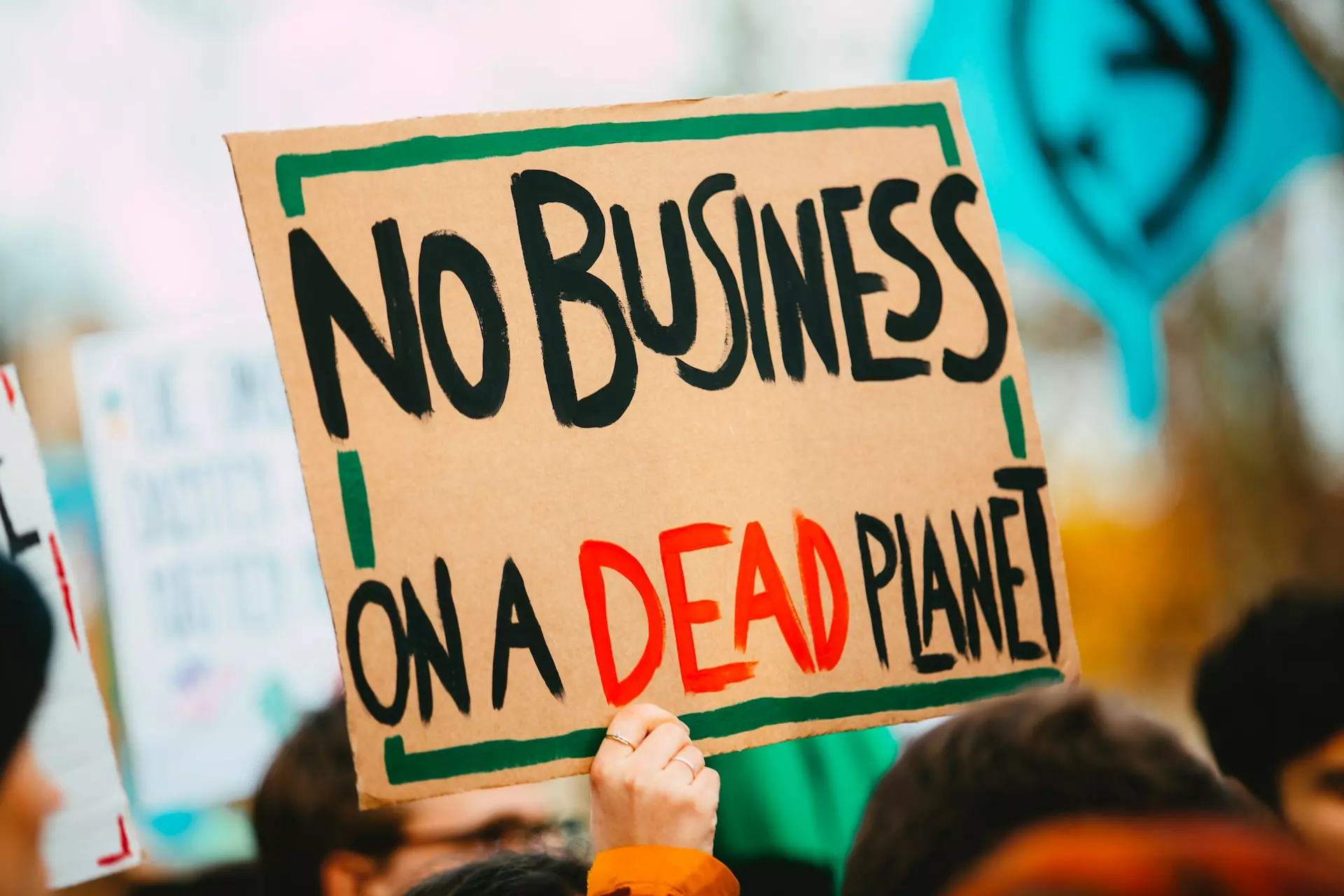 A protest banner reading 'No business on a dead planet'